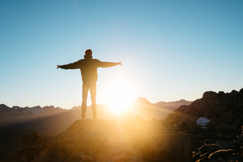 Silhouette of a Man Standing Outdoors at Sunset